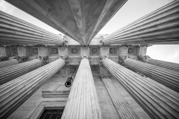 looking up at the columns of a building in a black and white photo .