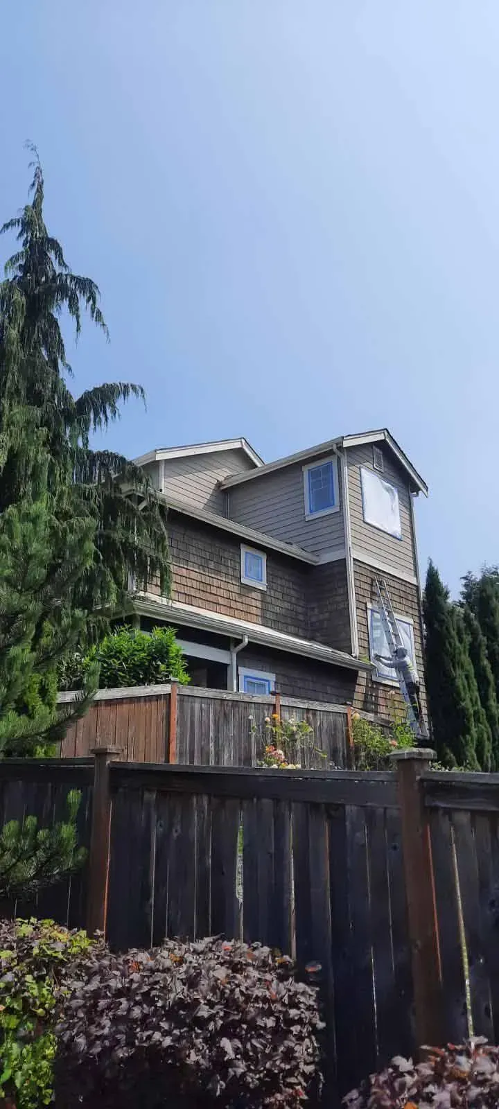 A large house with a wooden fence in front of it.