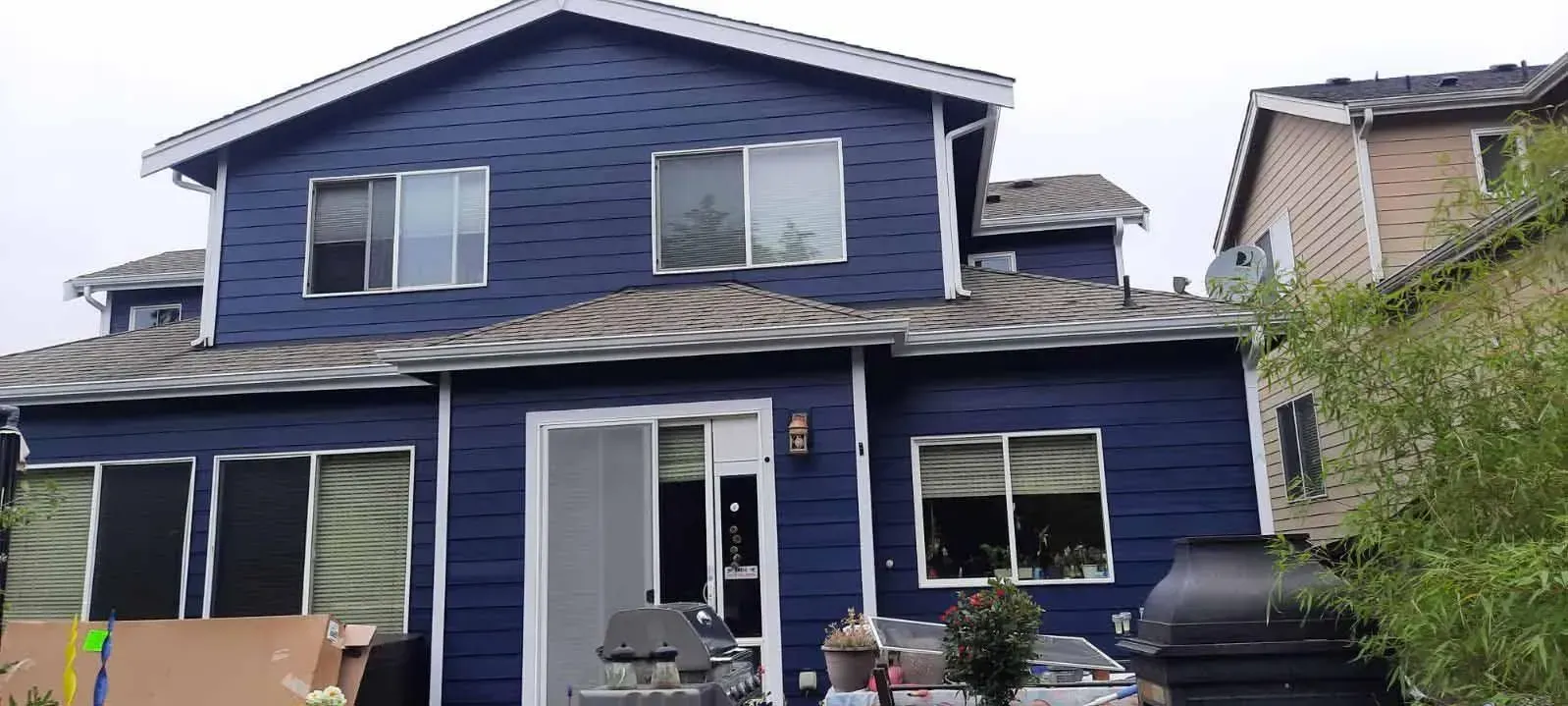 A blue house with a white roof is sitting on top of a hill.
