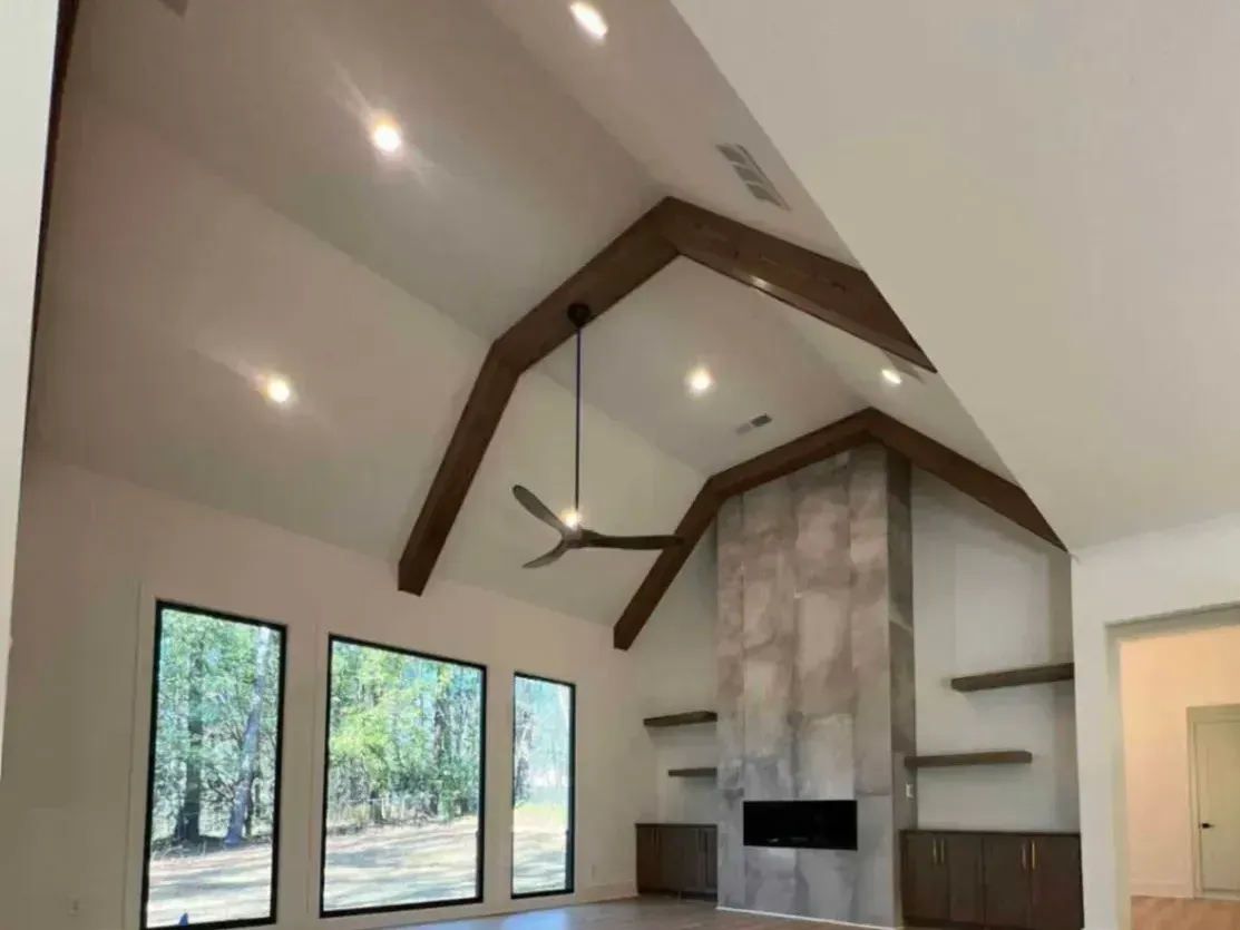 A living room with a vaulted ceiling and a fireplace
