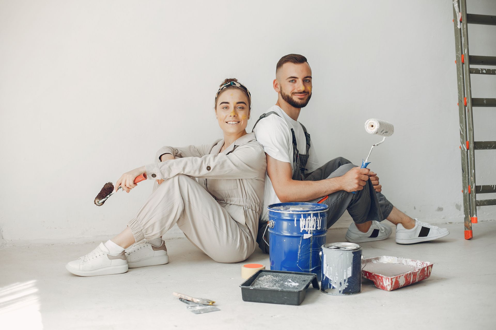 Two men are painting the side of a building.