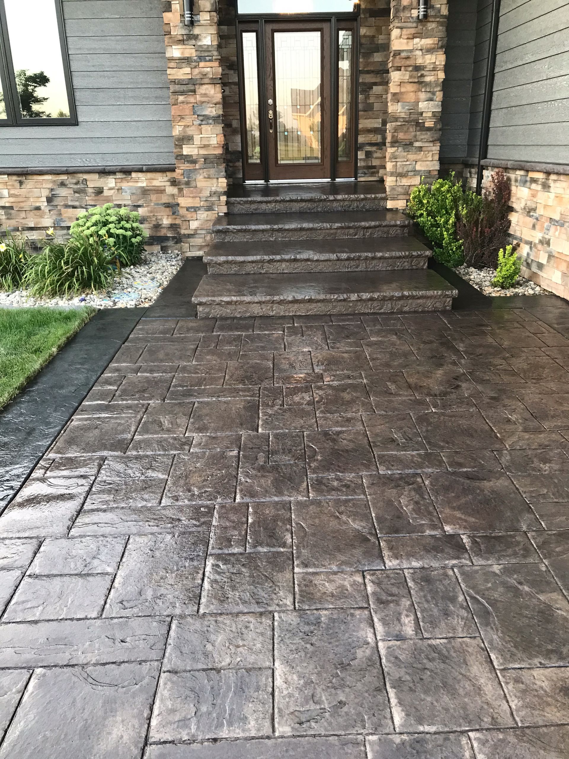 A concrete walkway leading to the front door of a house