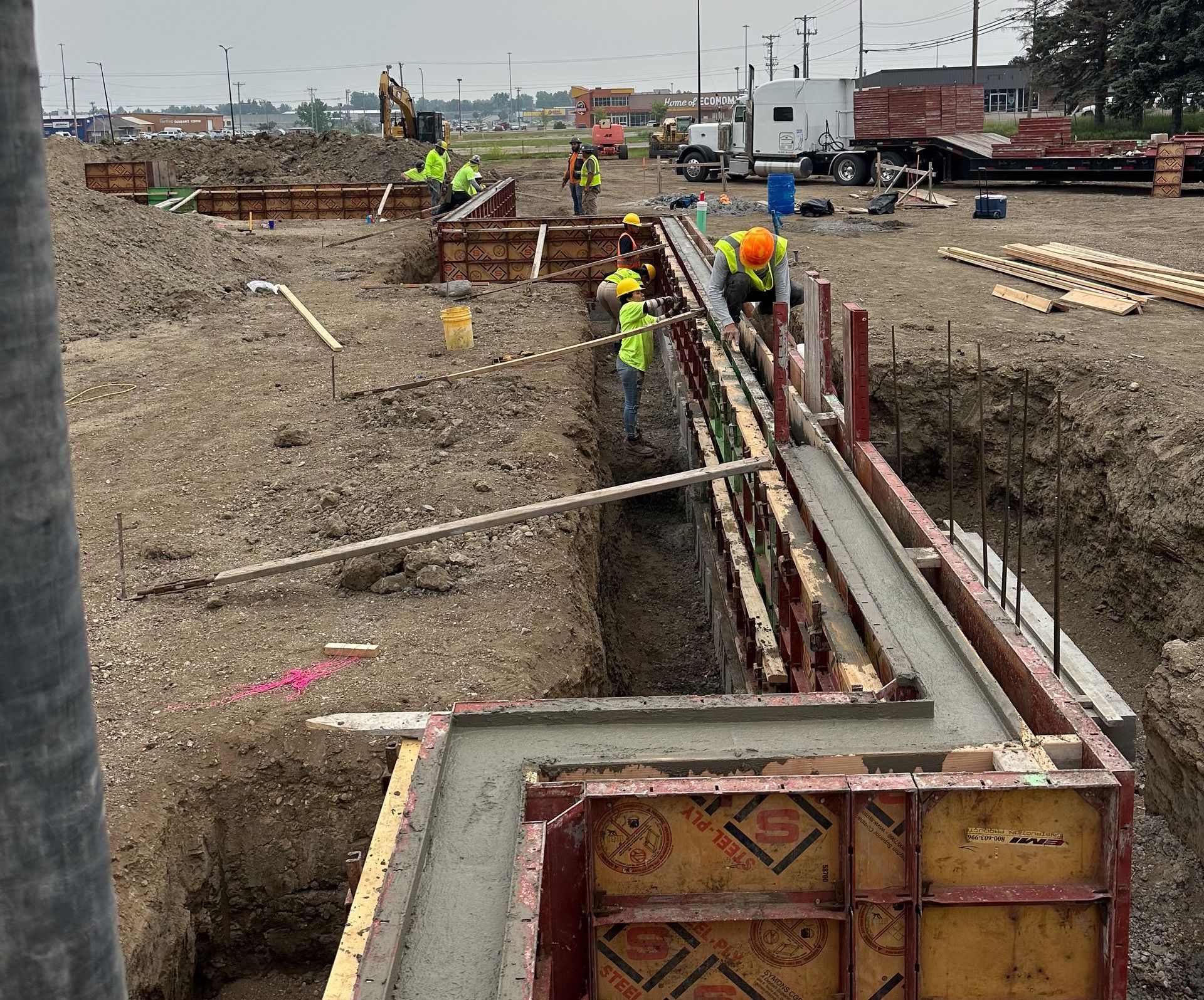 A concrete foundation for a house is being built in the woods.