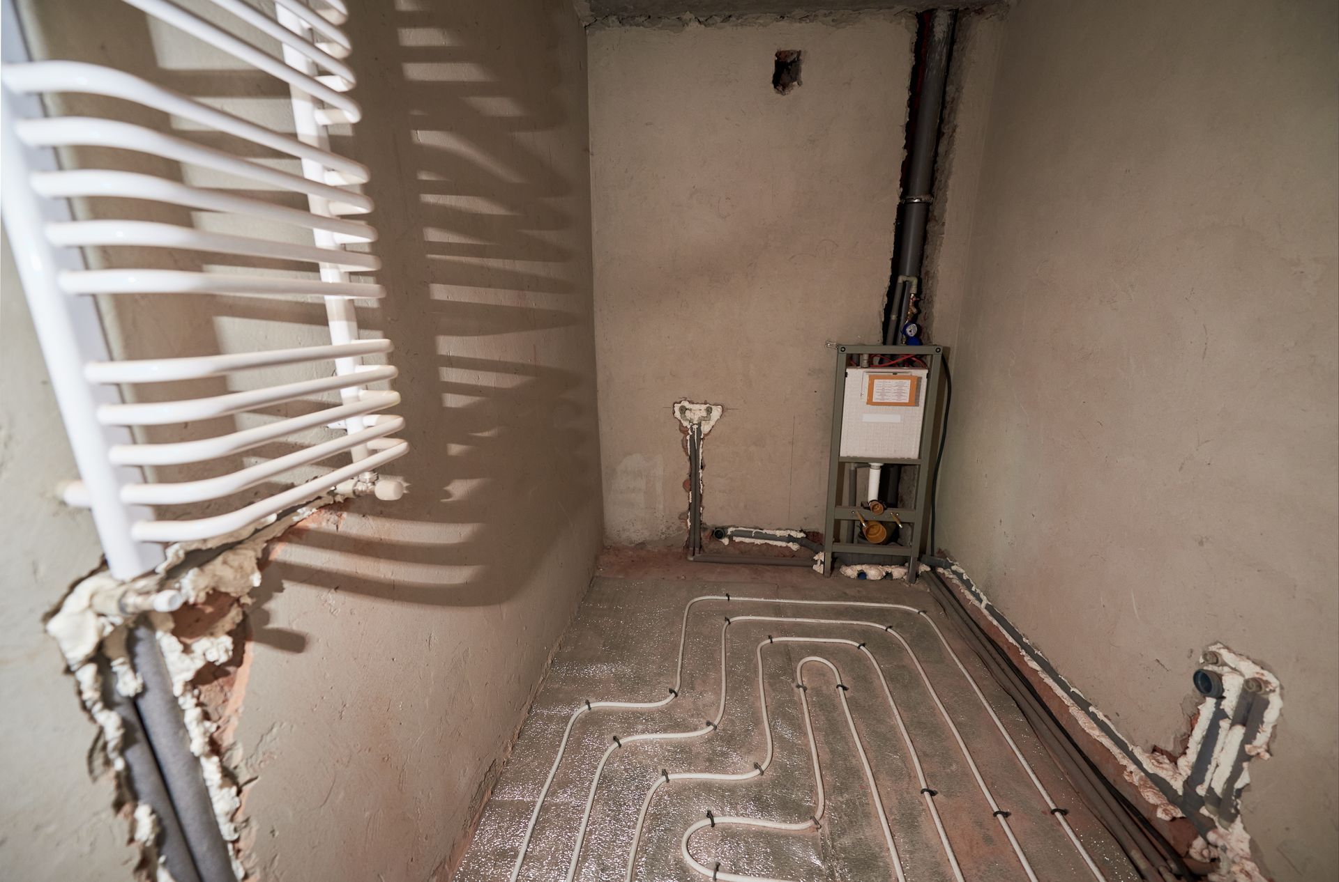 A room with a lot of pipes and wires on the floor.