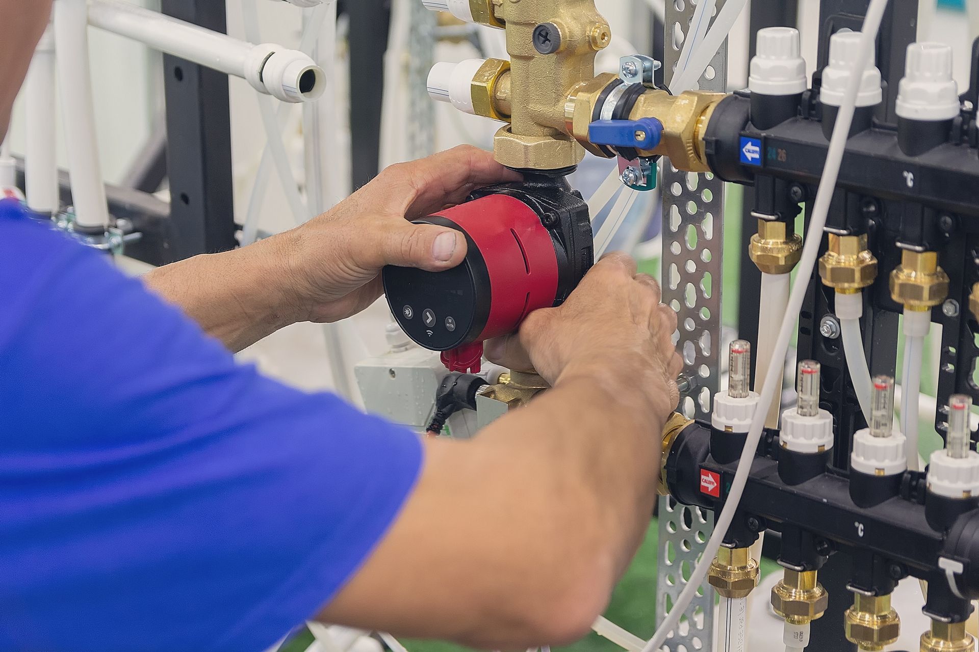 A man is working on a water pump in a factory.