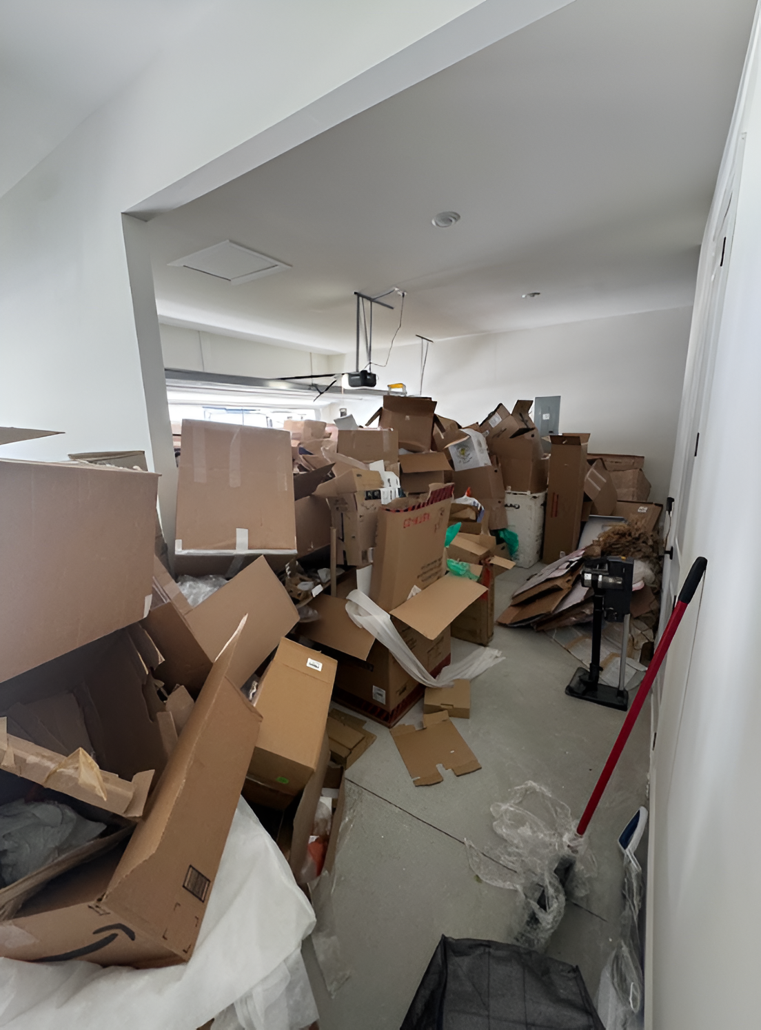 A room filled with a large pile of cardboard boxes, suggesting an unpacking or storage area.
