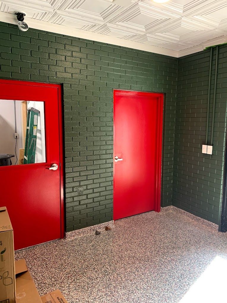 A room with green brick walls and red doors.