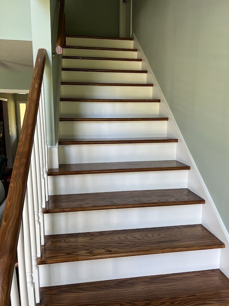 A set of stairs with white steps and wooden steps in a house.