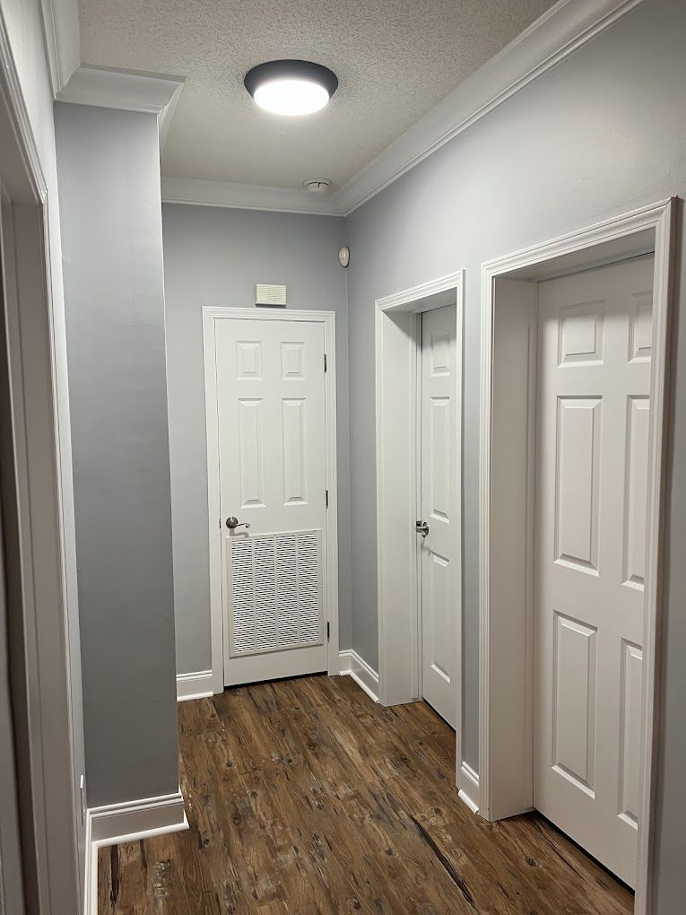 A hallway with a lot of doors and a light on the ceiling.