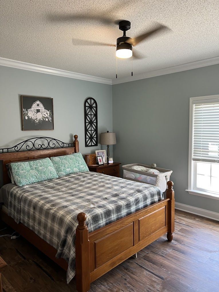 A bedroom with a king size bed and a ceiling fan.