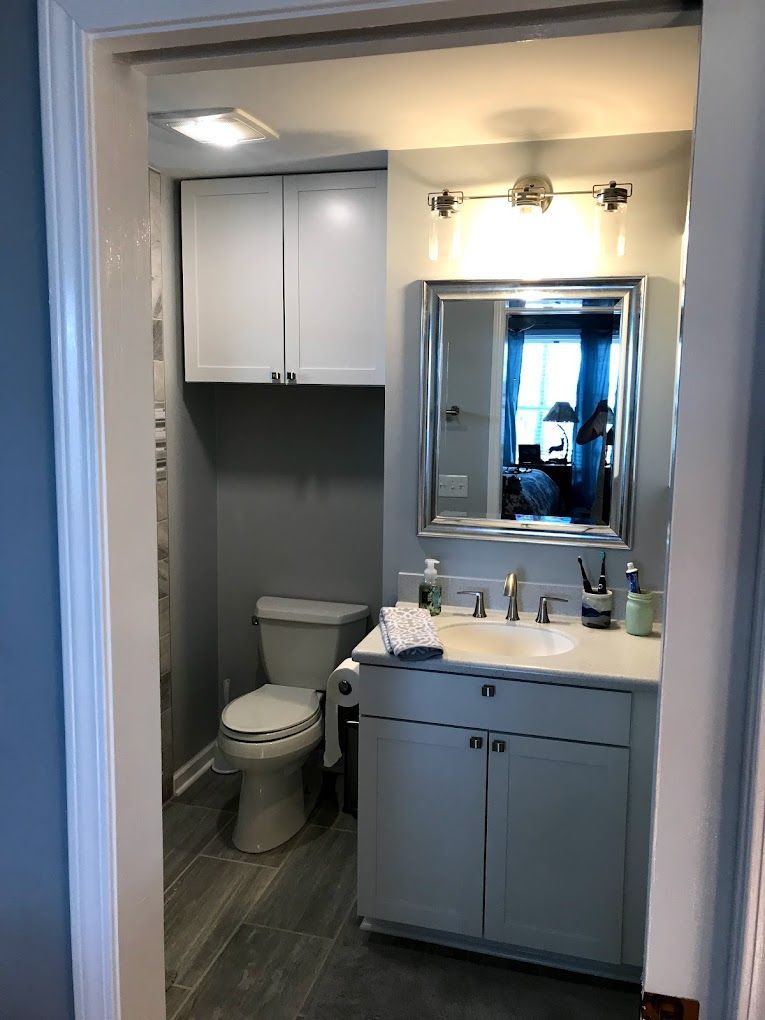A bathroom with a toilet , sink and mirror