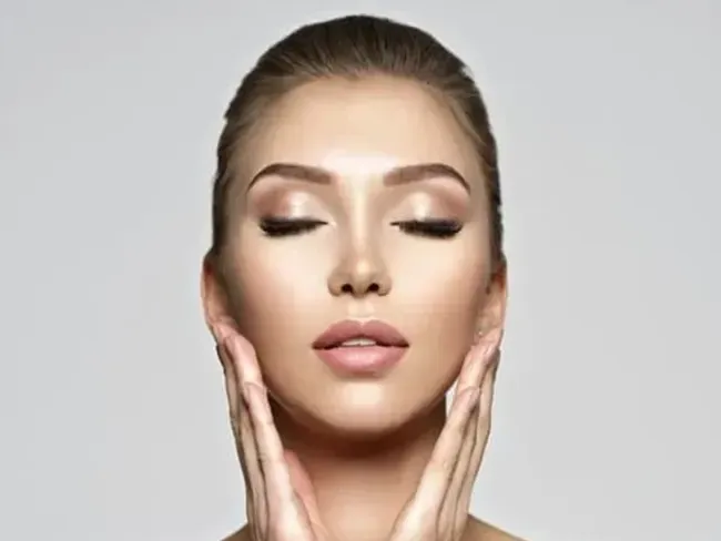 A close up of a woman 's face with beautiful face and skin after facial harmonization