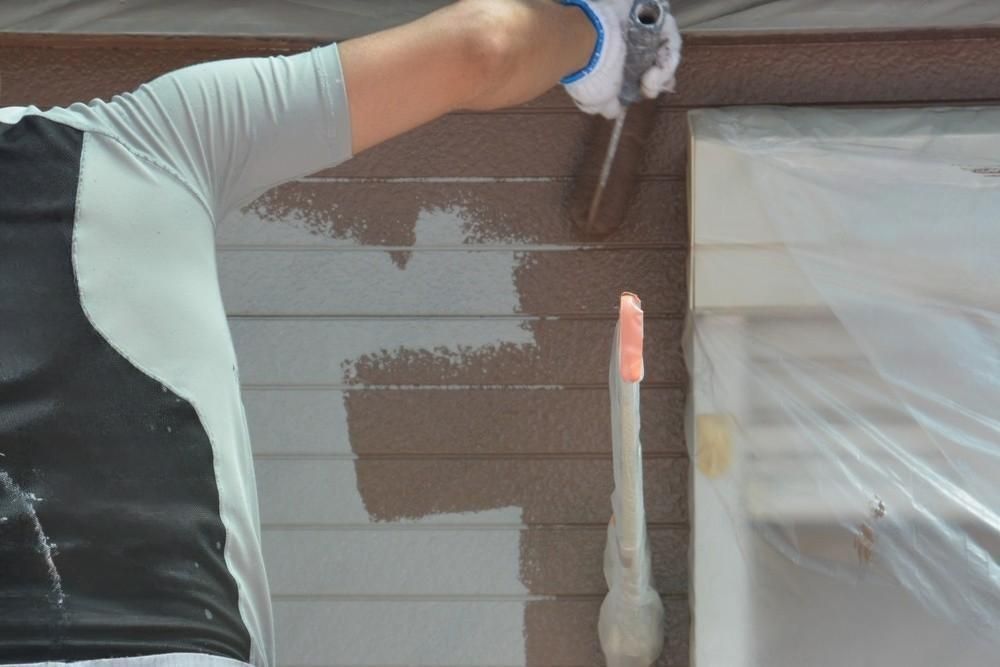 A man is painting a wall with a brush.