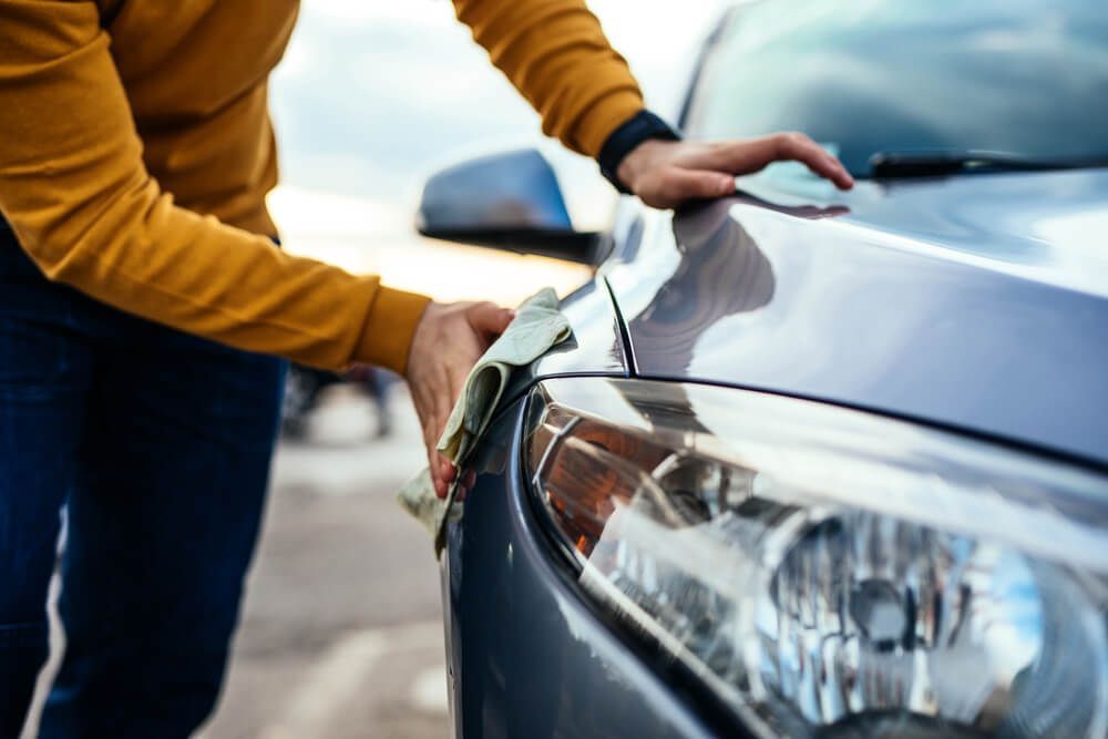 A Man is Cleaning His Car With a Cloth — Arafura Crash Repairs in Darwin, NT
