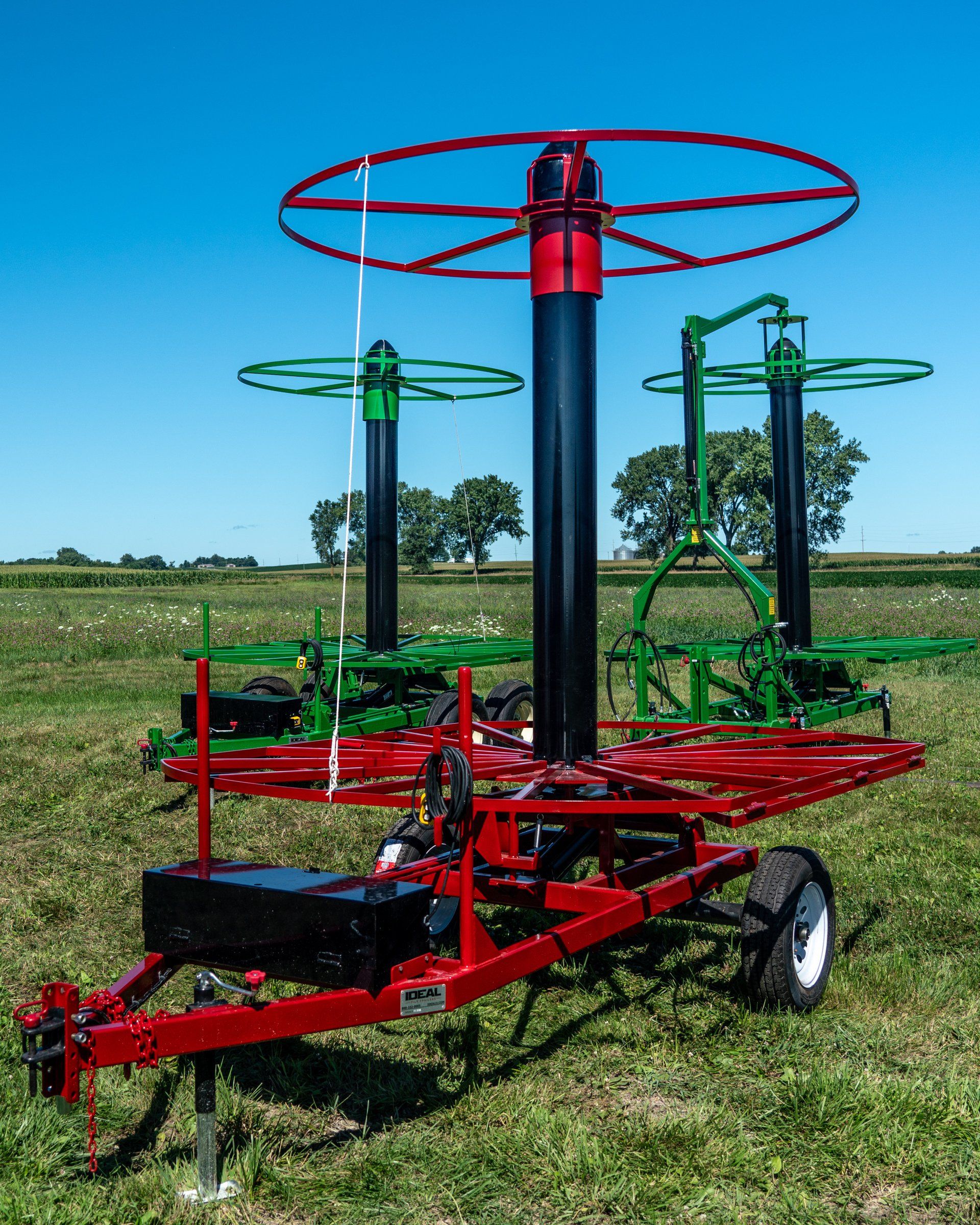 A red and green tile stringer trailer sitting in the middle of a grassy field.