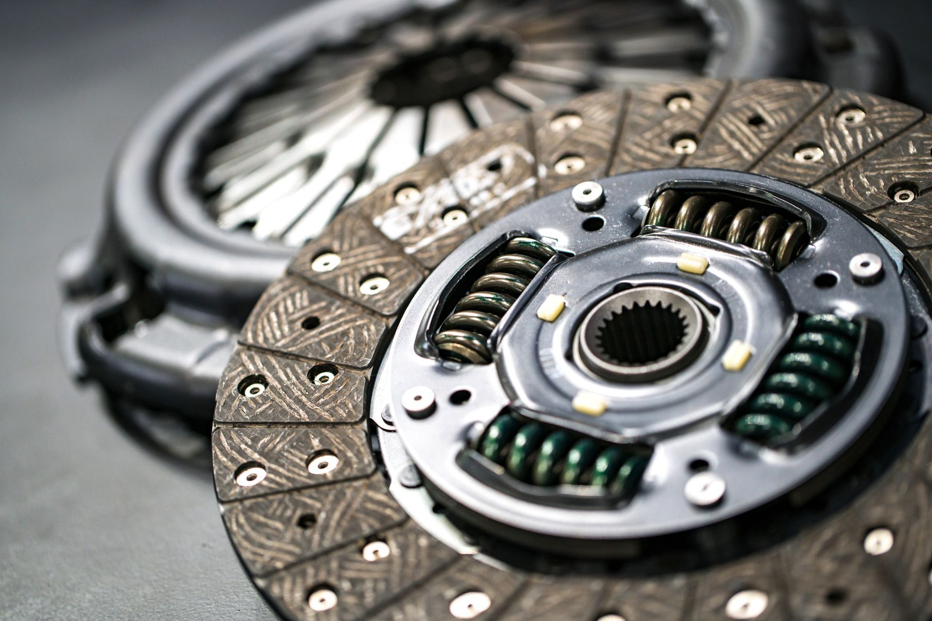 Clutch assembly parts: clutch disc with springs and pressure plate, close-up view.