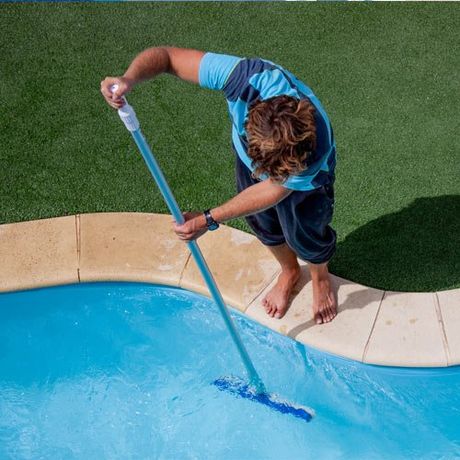 Brush — Male pool cleaner cleaning a blue pool in Riverside, CA