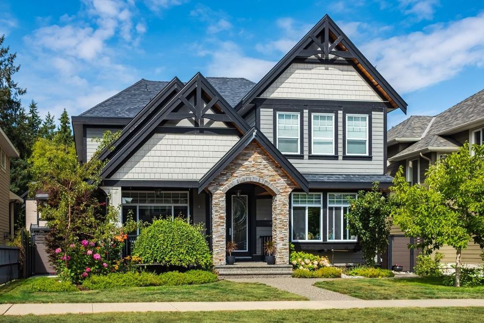 A large house with a lot of windows is sitting on top of a lush green lawn.