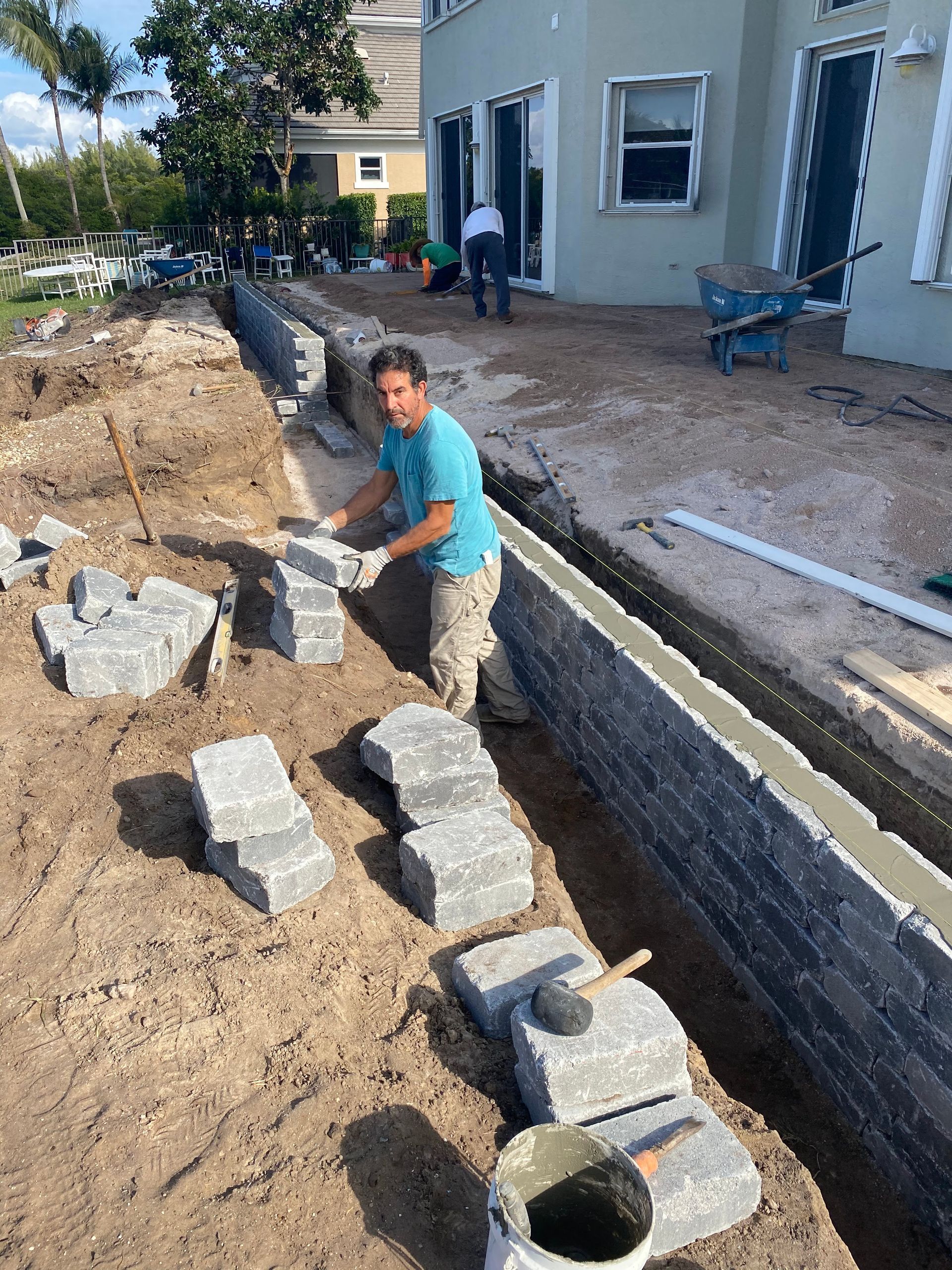 man laying bricks for retaining wall