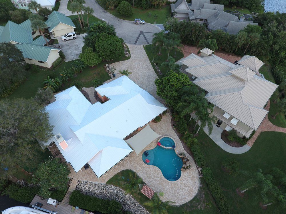 aerial view of residential home with paved pool