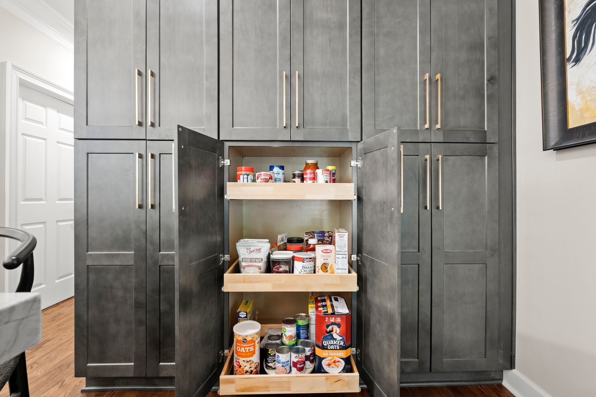 A kitchen pantry with a pull out drawer filled with food.