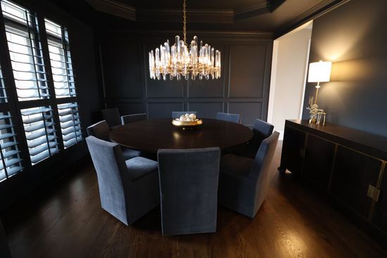 A dining room with a round table and chairs and a chandelier