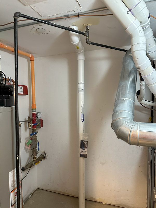 There are a lot of pipes hanging from the ceiling in this room.