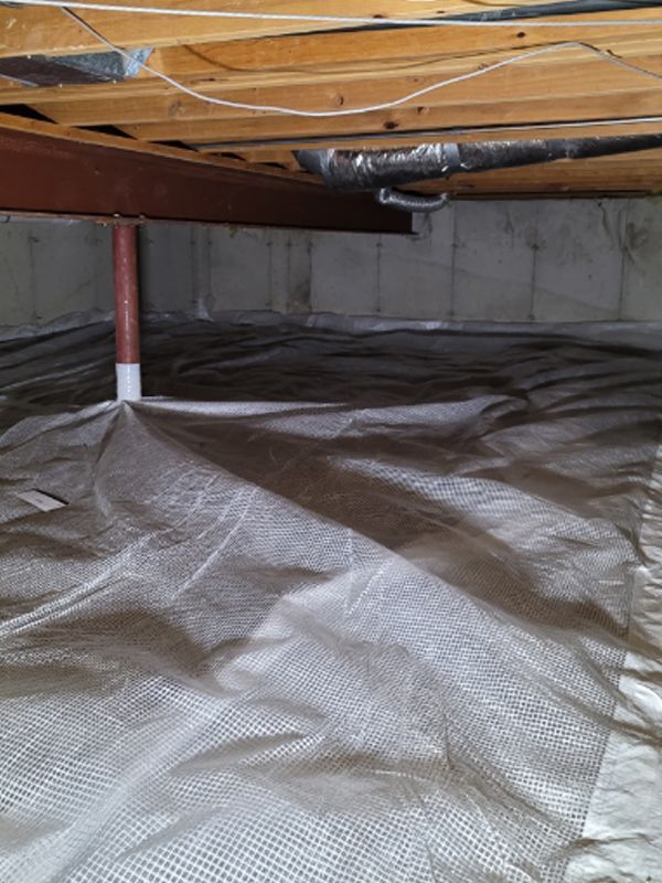 A basement with a drainage mat on the floor.