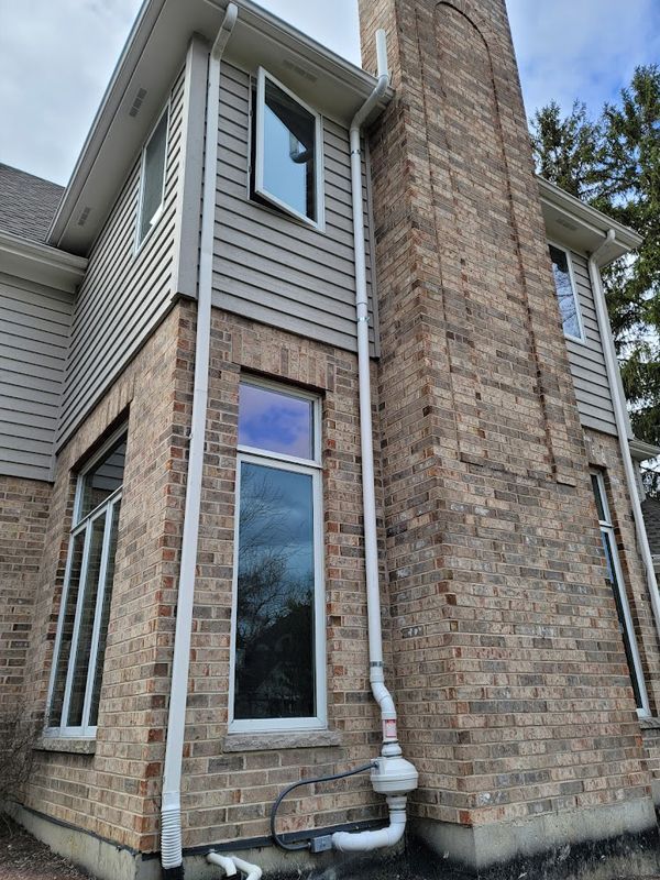 A large brick house with a chimney and a lot of windows.