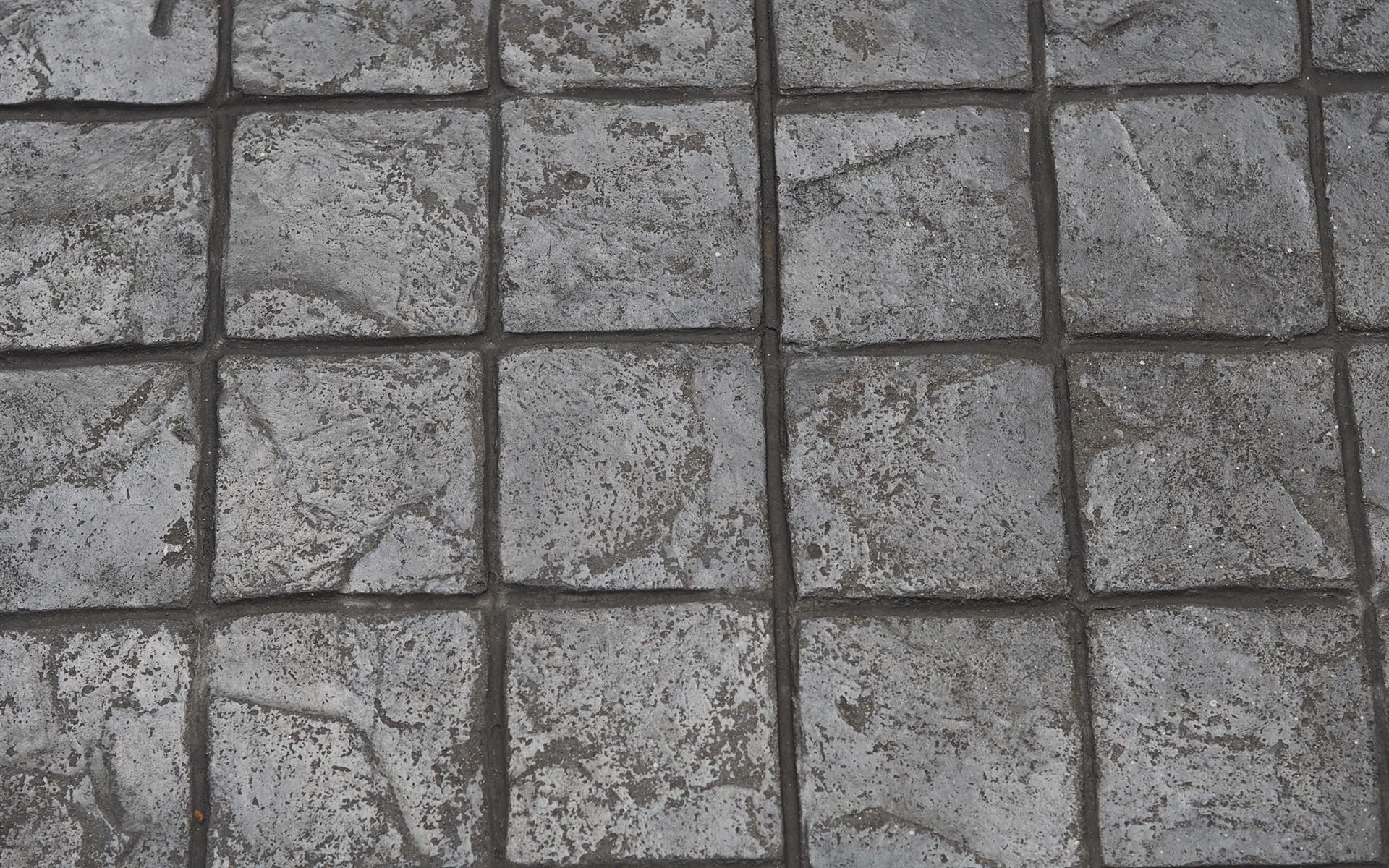 A black and white photo of a gray tile floor.