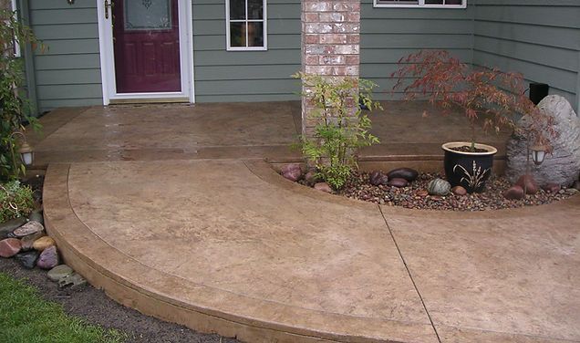 A concrete walkway leading to the front door of a house.