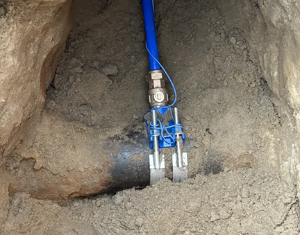 A repairman in overalls and a woman discuss paperwork in a kitchen with blue cabinets.