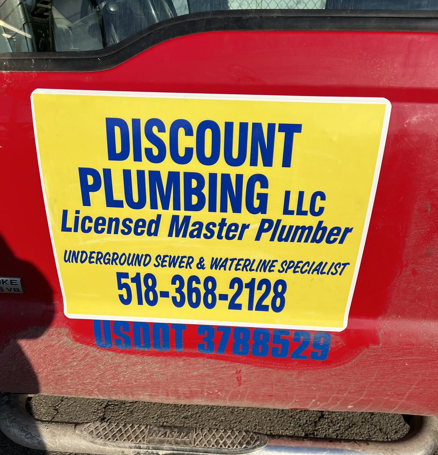 Man lying under a kitchen sink, fixing plumbing.