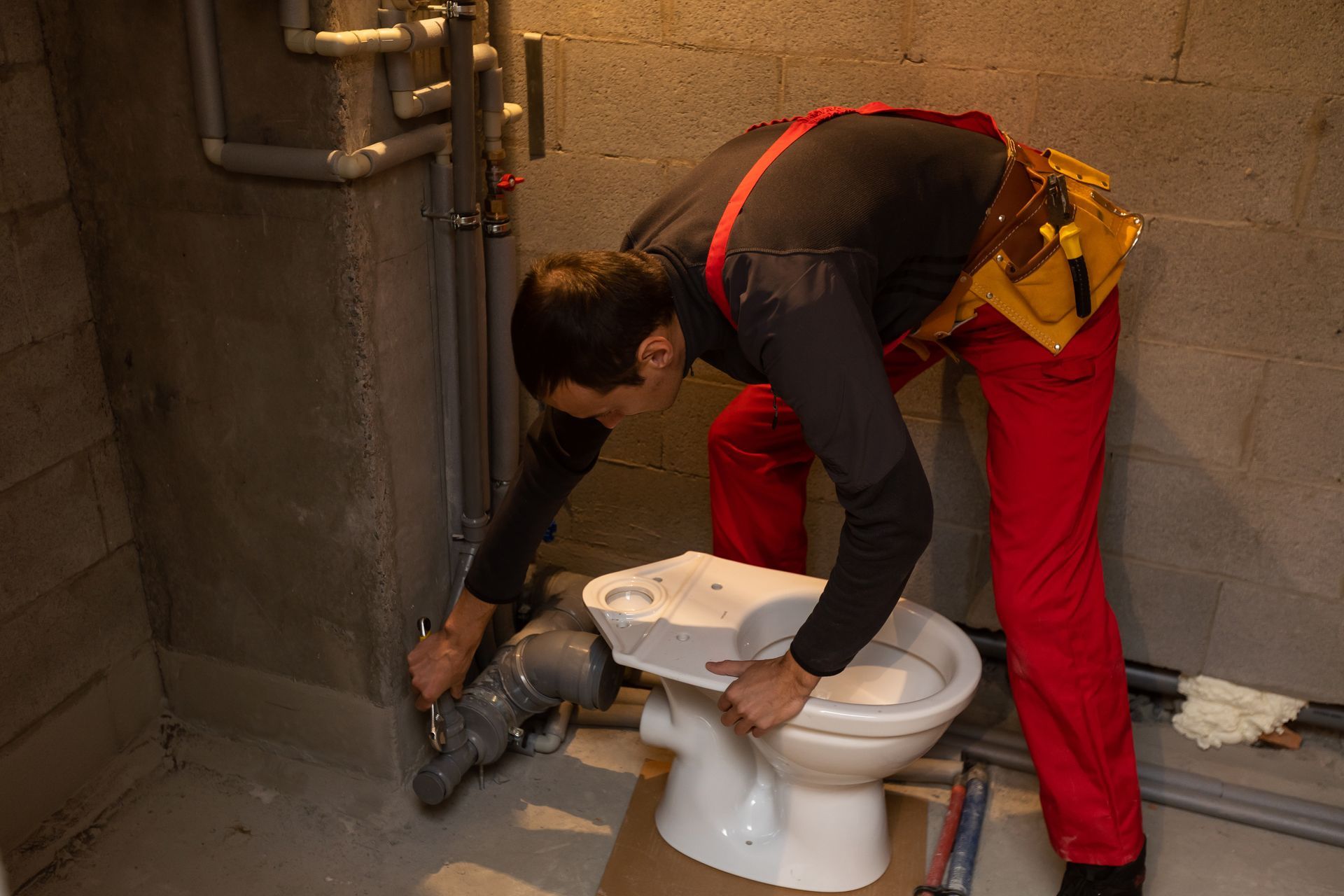 A man is installing a toilet in a bathroom.