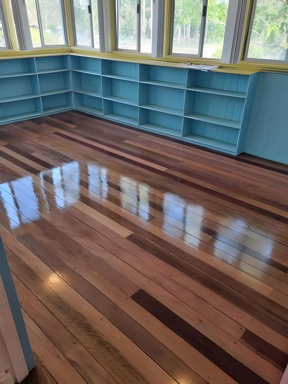 A Room With a Wooden Floor and Blue Shelves — European Floor Sanding In Mount Louisa, QLD