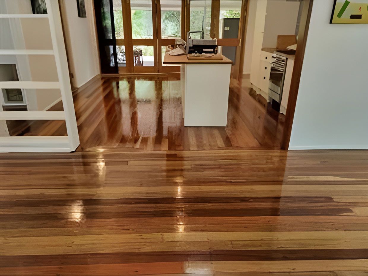 A Kitchen With a Wooden Floor and a White Island — European Floor Sanding In Mount Louisa, QLD