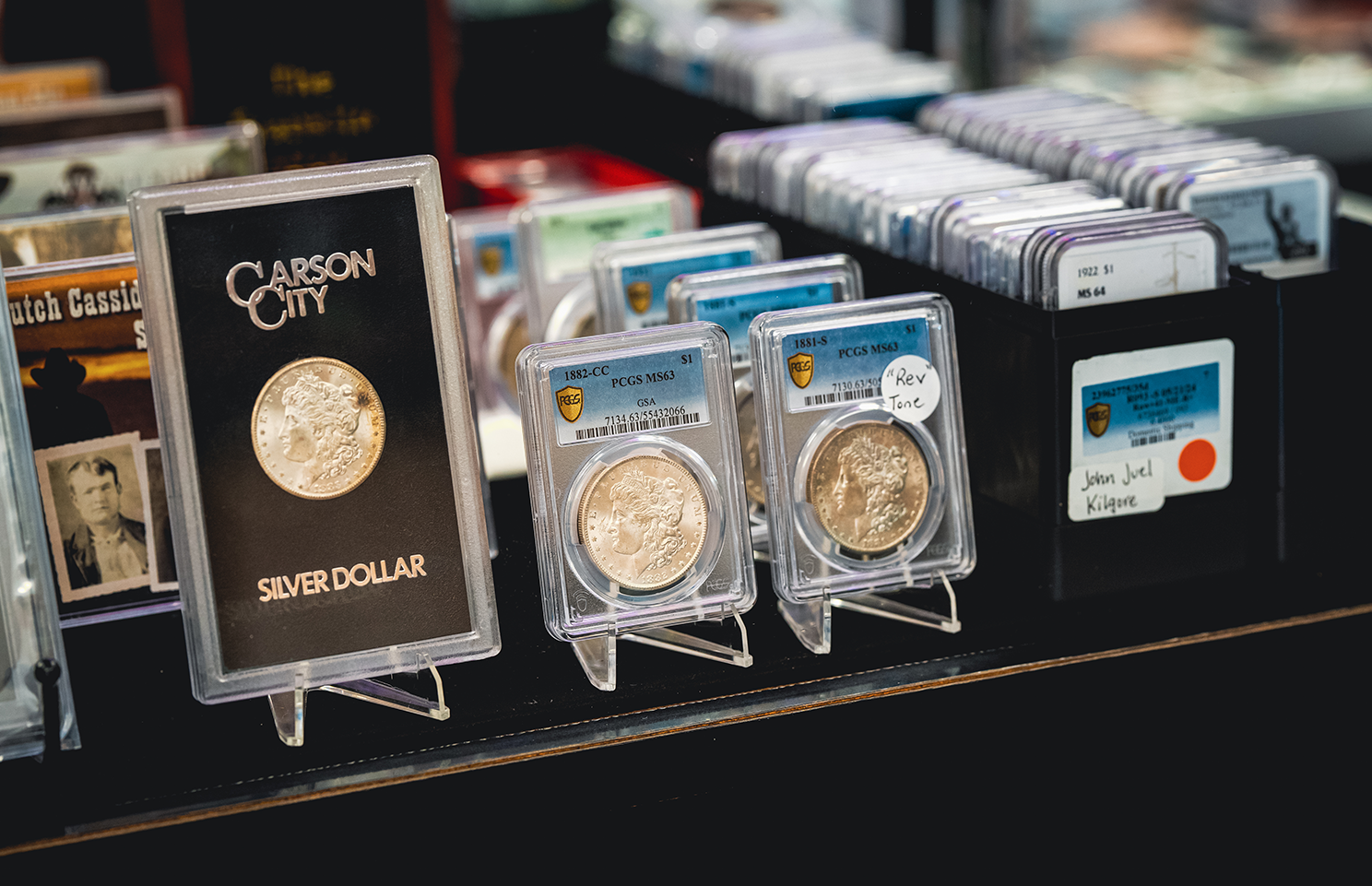Display of silver coins in protective cases at a coin show.