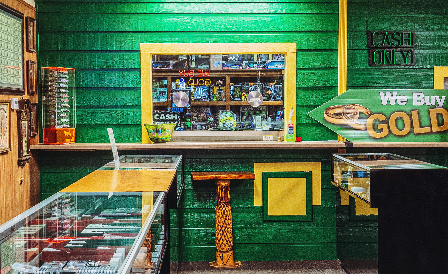 green walls, counter with display cases, window with items for sale, and a