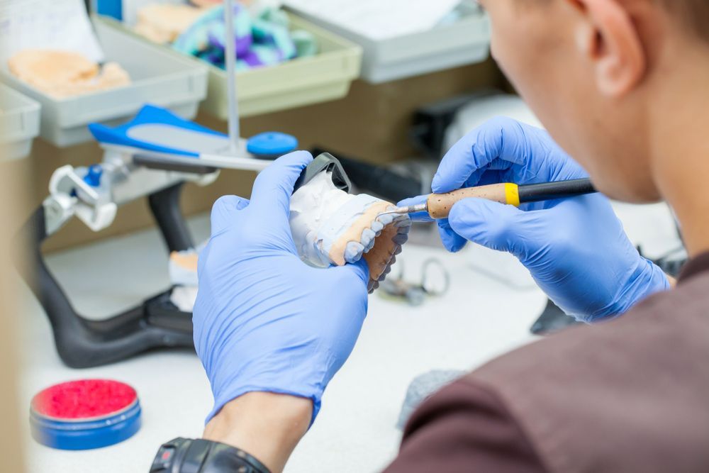 A Dental Technician Is Working On A Denture — Dentures in Newcastle, NSW