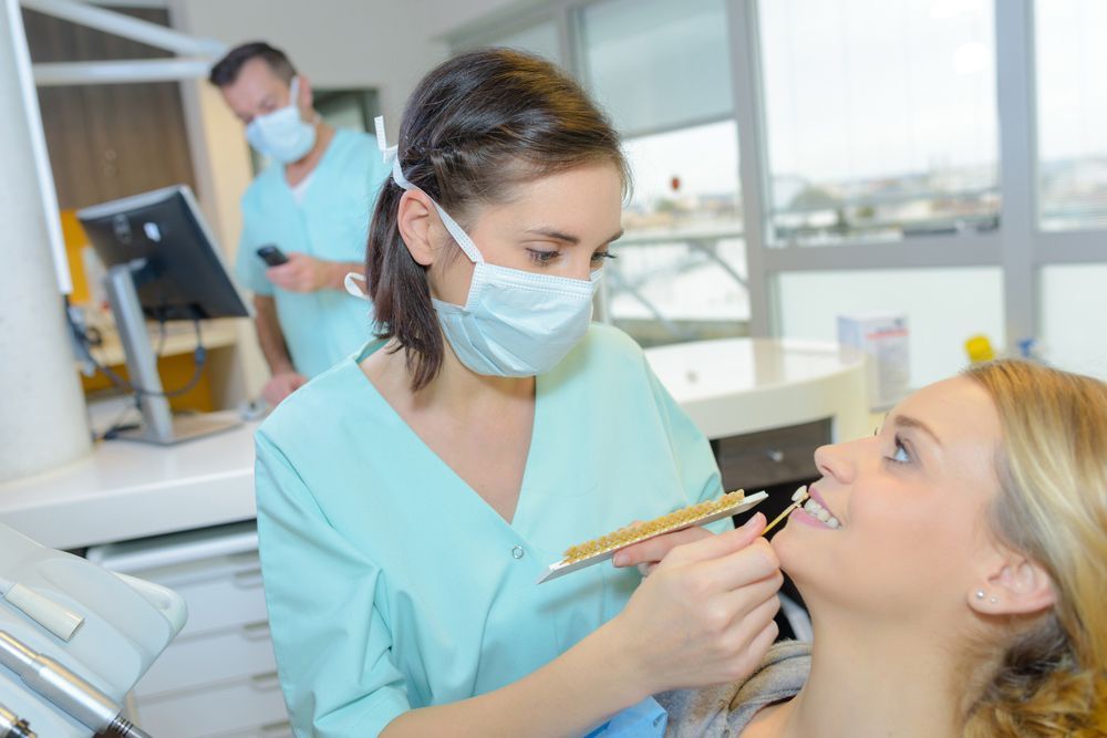 A Female Dentist Is Examining A Woman 's Teeth In A Dental Office — Denture Clinic in NSW, NSW