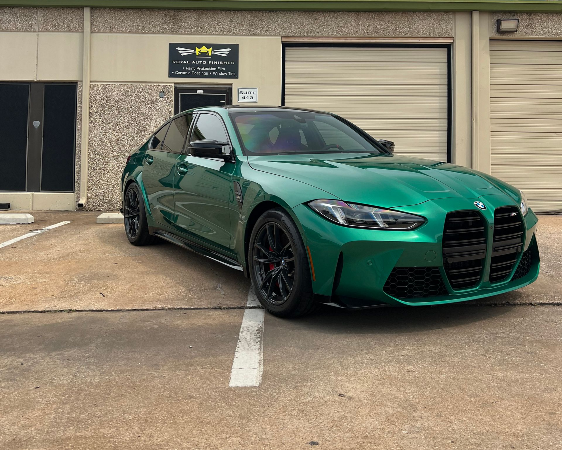 Red Porsche 911 in a shop, possibly for detailing, with black wheels.