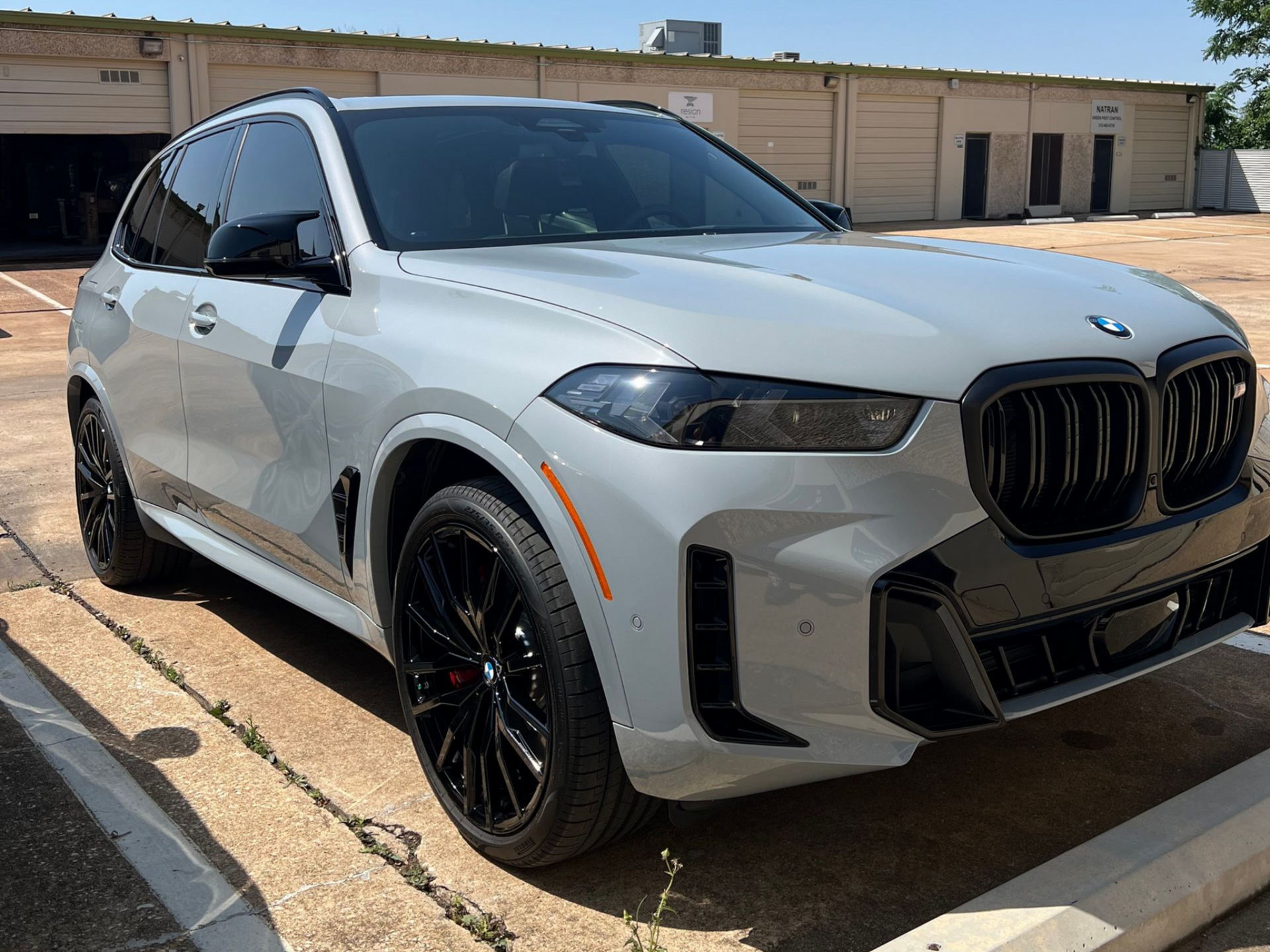 Gray BMW SUV with black wheels parked outdoors.