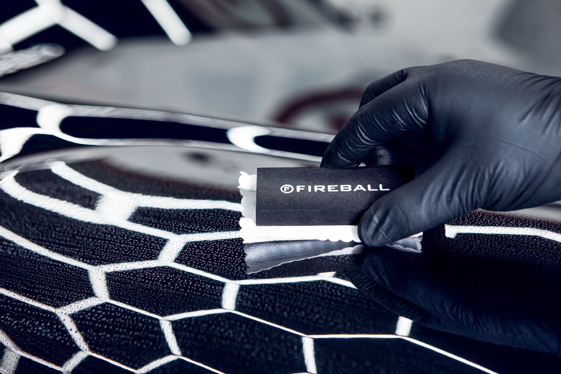 a person wearing black gloves is holding a card that says fireball on it .