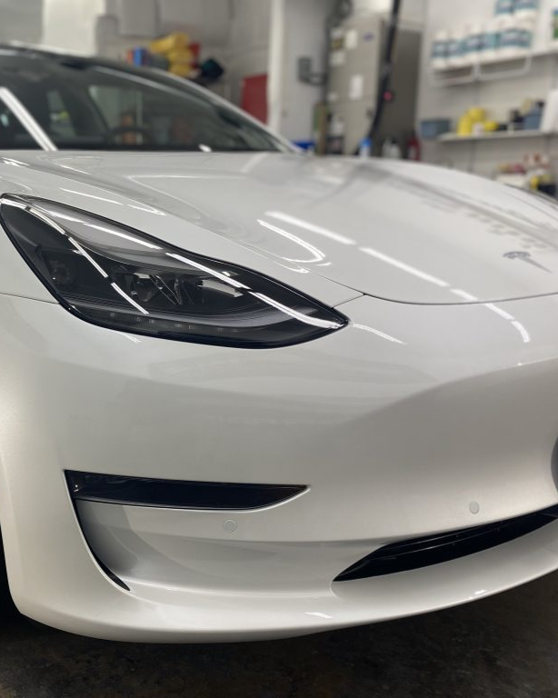 Blue car door with a black handle and white paint marks.