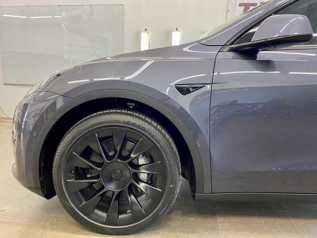 a close up of a tesla model y with black wheels