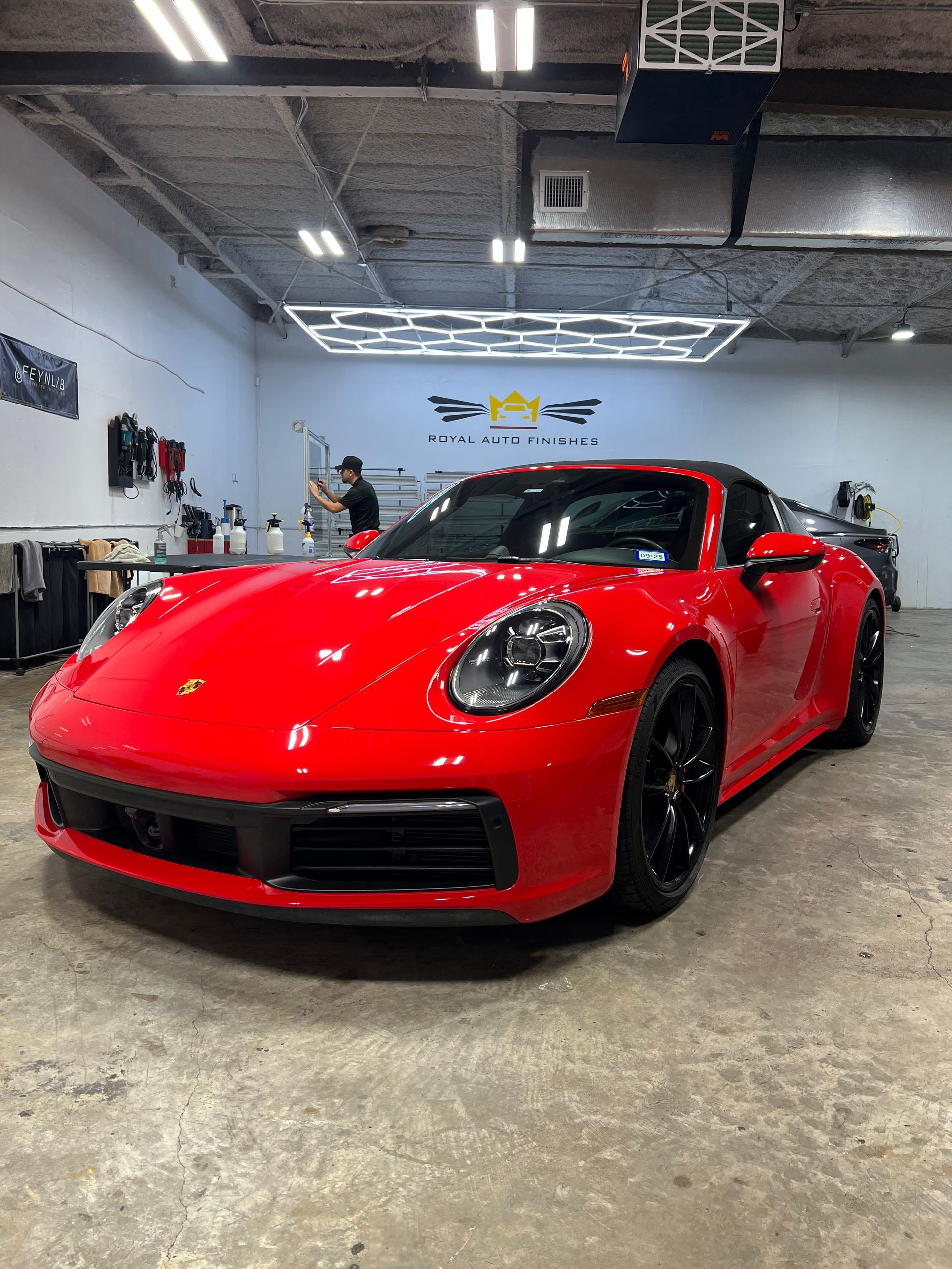 Red Porsche 911 sports car inside a bright shop.