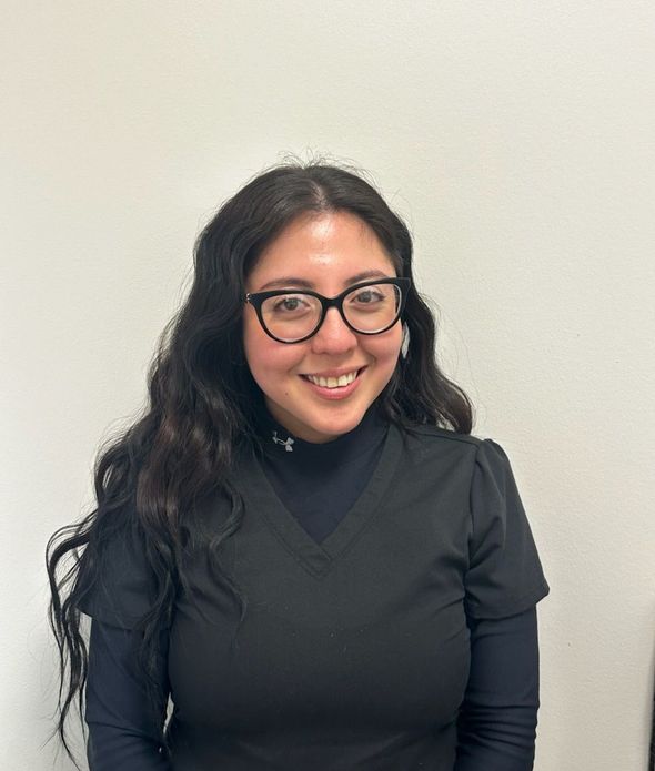 A woman wearing glasses and a black shirt is smiling for the camera.