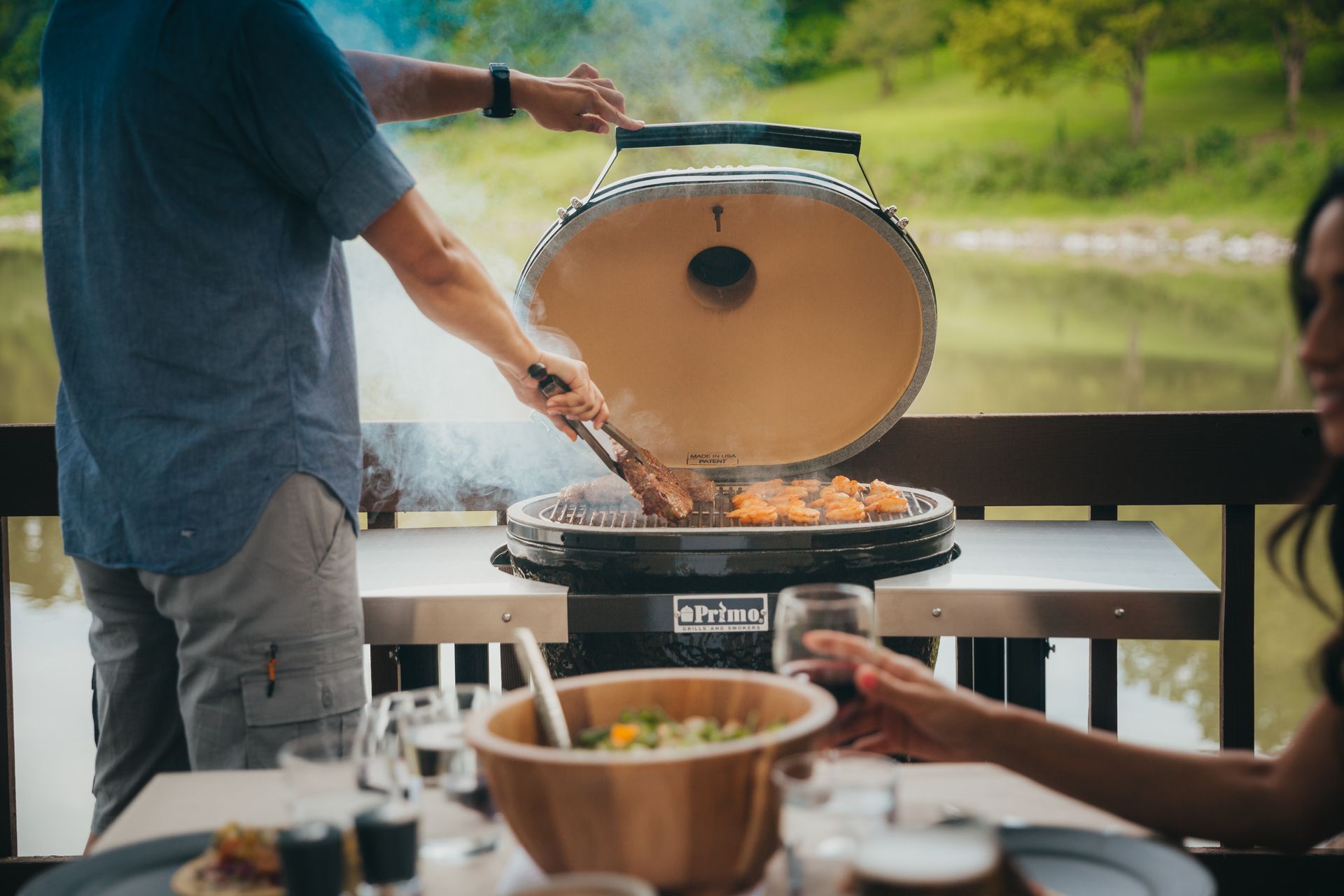 Een man en een vrouw bereiden voedsel op een grill.