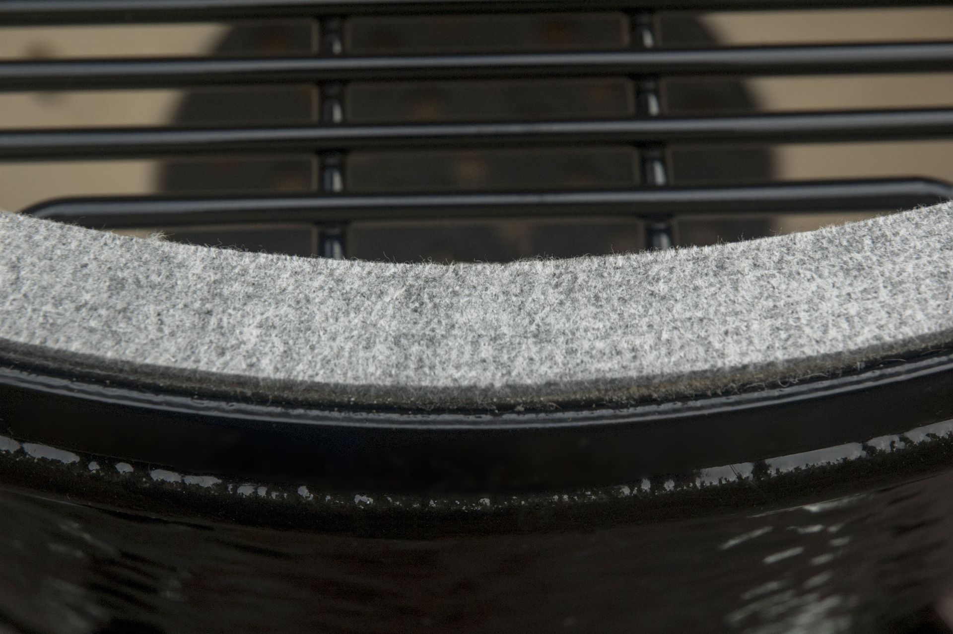 Een close-up van een grill met een grijs kussen erop.