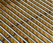 Een close-up van een metalen rooster op een houten oppervlak.